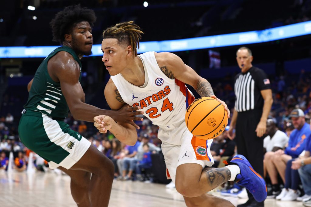 Dec 14, 2022; Tampa, Florida, USA;Florida Gators guard Riley Kugel (24) drives to the basket as Ohio Bobcats guard Elmore James (1) defends during the second half at Amalie Arena. Mandatory Credit: Kim Klement-Imagn Images