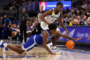 Dec 27, 2022; Milwaukee, Wisconsin, USA;  Seton Hall Pirates guard Jaquan Sanders (20) and Marquette Golden Eagles guard Kam Jones (1) chase the loose ball during the first half at Fiserv Forum. Mandatory Credit: Jeff Hanisch-Imagn Images