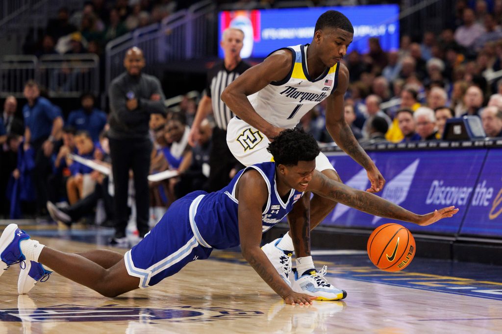 Dec 27, 2022; Milwaukee, Wisconsin, USA; Seton Hall Pirates guard Jaquan Sanders (20) and Marquette Golden Eagles guard Kam Jones (1) chase the loose ball during the first half at Fiserv Forum. Mandatory Credit: Jeff Hanisch-Imagn Images