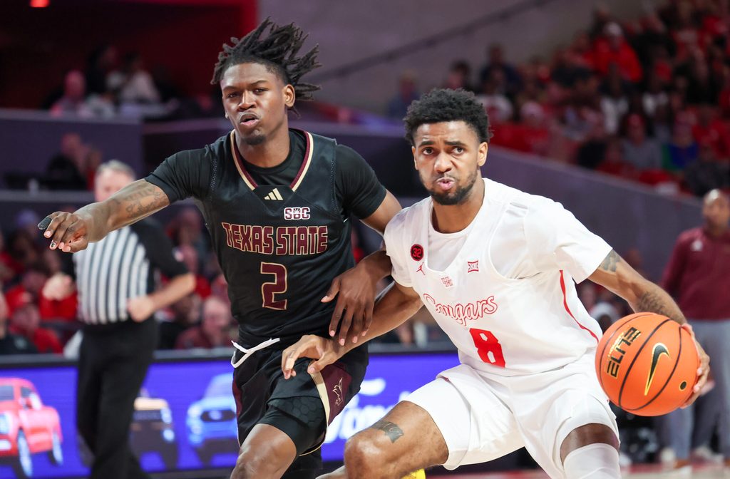 Dec 21, 2023; Houston, Texas, USA; Houston Cougars guard Mylik Wilson (8) dribbles against Texas State Bobcats guard Dontae Horne (2) in the second half at Fertitta Center. Mandatory Credit: Thomas Shea-Imagn Images