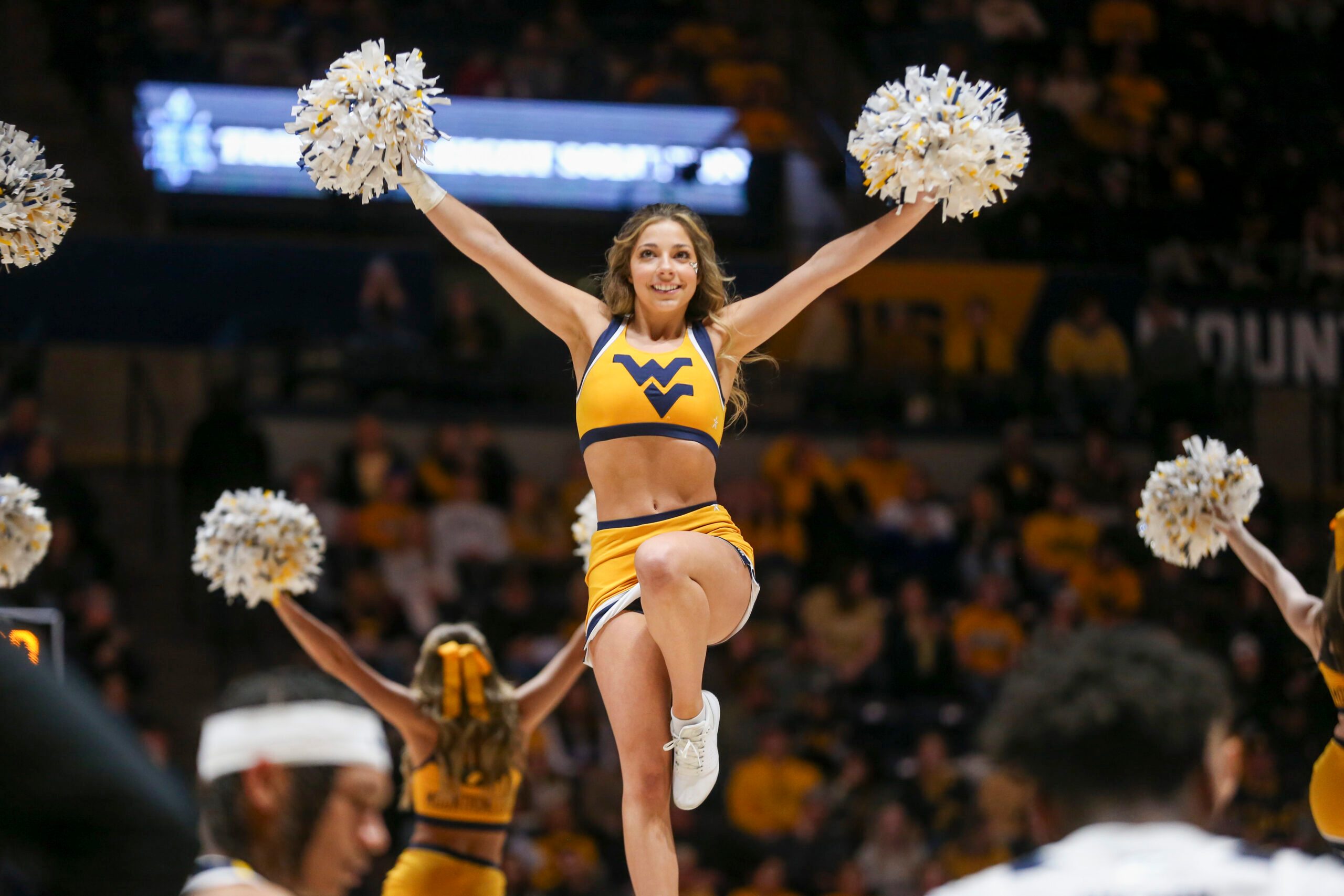 Jan 20, 2024; Morgantown, West Virginia, USA; A West Virginia Mountaineers cheerleader performs during the second half against the Kansas Jayhawks at WVU Coliseum. Mandatory Credit: Ben Queen-Imagn Images