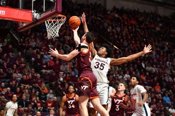 Feb 19, 2024; Blacksburg, Virginia, USA; Virginia Tech Hokies forward Robbie Beran (31) lays the ball up while Virginia Cavaliers guard Leon Bond III (35) defends during the second half at Cassell Coliseum. Mandatory Credit: Brian Bishop-Imagn Images