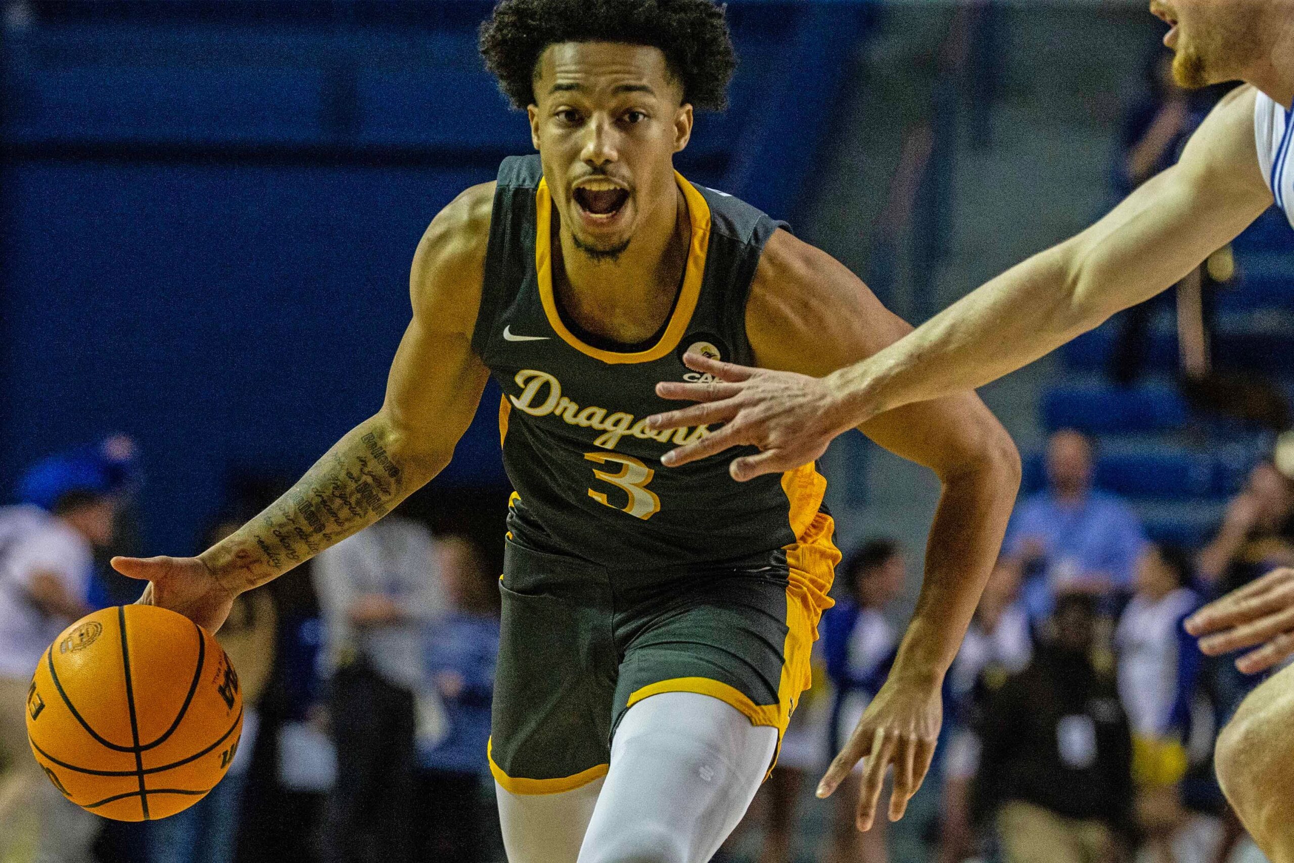 Drexel Dragons guard Jamie Bergens (3) dribbles against the Delaware Fightin' Blue Hens guard Christian Ray (5) during critical late-season CAA basketball game at the Bob Carpenter Center in Newark, Monday, Feb. 26, 2024. Drexel won 70-60.