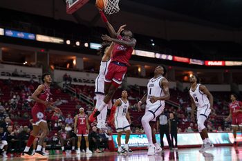 Feb 27, 2024; Fresno, California, USA; Fresno State Bulldogs guard Jalen Weaver (5) makes a layup in front of Utah State Aggies guard Javon Jackson (22) in the second half at the Save Mart Center. Mandatory Credit: Cary Edmondson-Imagn Images