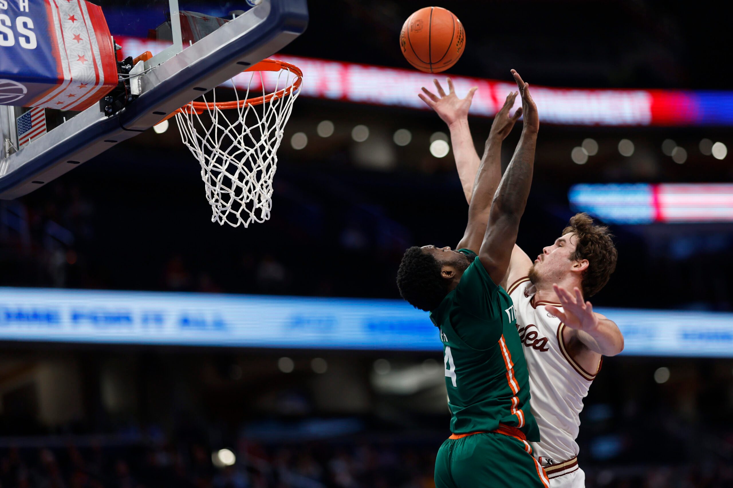 Mar 12, 2024; Washington, D.C., USA; Boston College Eagles forward Quinten Post (12) shoots the ball as Miami (Fl) Hurricanes guard Bensley Joseph (4) defends in the second half at Capital One Arena. Mandatory Credit: Geoff Burke-Imagn Images