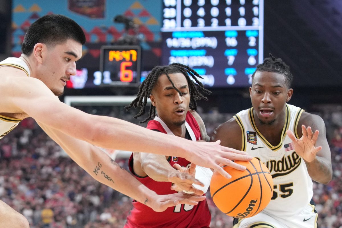 Purdue Boilermakers center Zach Edey (15), North Carolina State Wolfpack guard Breon Pass (10) and Purdue Boilermakers guard Lance Jones (55) go for the ball during the NCAA Menâ€™s Basketball Tournament Final Four game, Saturday, April 6, 2024, at State Farm Stadium in Glendale, Ariz.