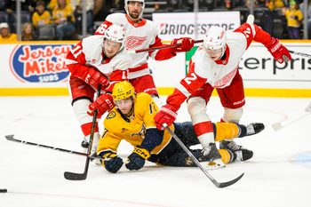 Oct 19, 2024; Nashville, Tennessee, USA;  Nashville Predators right wing Luke Evangelista (77), Detroit Red Wings right wing Vladimir Tarasenko (11), and defenseman Olli Maatta (2) fight for the puck during the third period at Bridgestone Arena. Mandatory Credit: Steve Roberts-Imagn Images