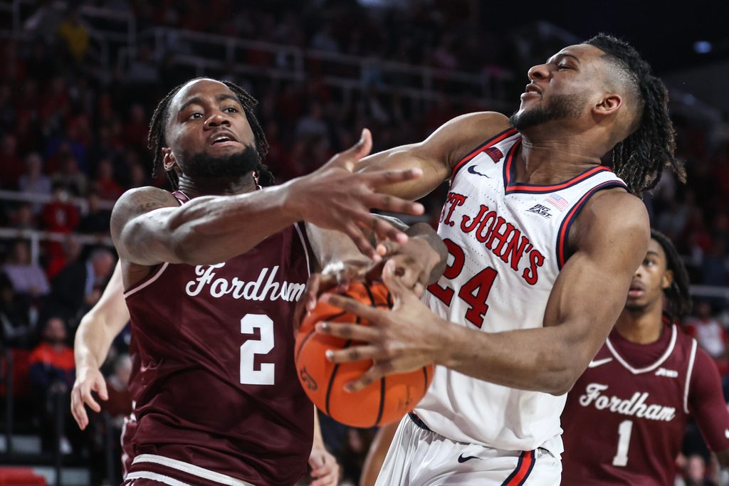 Nov 4, 2024; Queens, New York, USA; Fordham Rams forward Romad Dean (2) and St. John's Red Storm forward Zuby Ejiofor (24) fight for a loose ball in the second half at Carnesecca Arena. Mandatory Credit: Wendell Cruz-Imagn Images