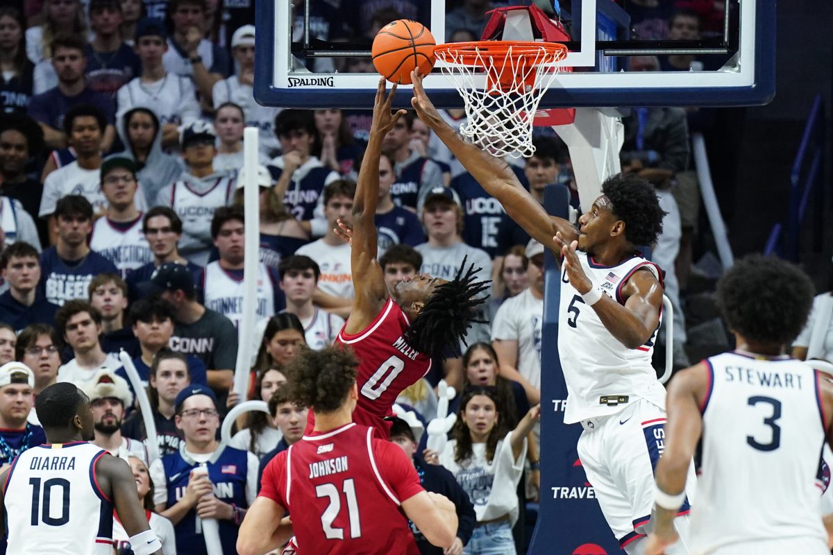 Nov 6, 2024; Storrs, Connecticut, USA; Sacred Heart Pioneers guard Keyishon Miller (0) makes the basket against Connecticut Huskies center Tarris Reed Jr. (5) in the second half at Harry A. Gampel Pavilion. Mandatory Credit: David Butler II-Imagn Images
