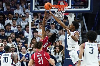 Nov 6, 2024; Storrs, Connecticut, USA; Sacred Heart Pioneers guard Keyishon Miller (0) makes the basket against Connecticut Huskies center Tarris Reed Jr. (5) in the second half at Harry A. Gampel Pavilion. Mandatory Credit: David Butler II-Imagn Images