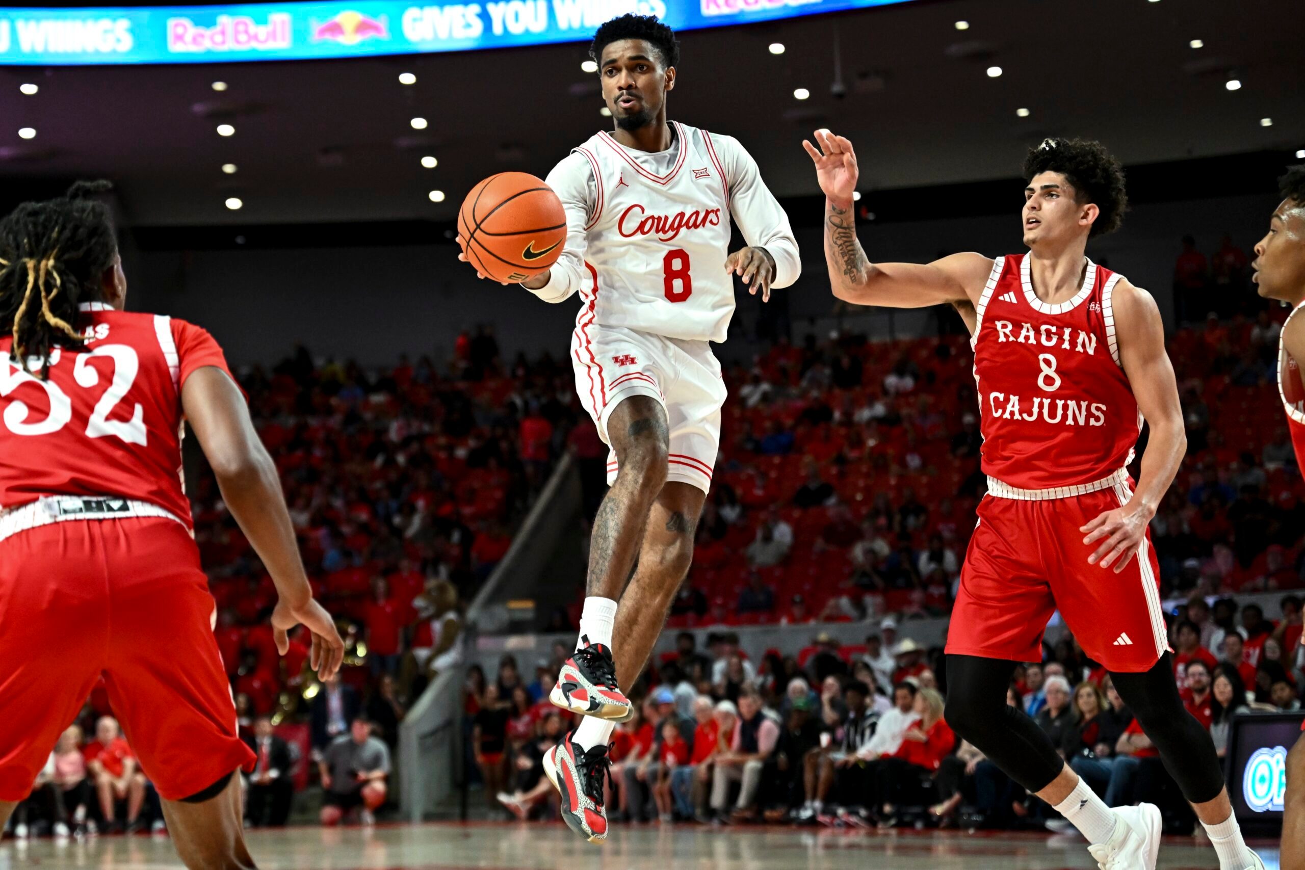 Nov 13, 2024; Houston, Texas, USA; Houston Cougars guard Mylik Wilson (8) looks to pass the ball as Louisiana Ragin Cajuns guard Mostapha El Moutaouakkil (8) defends during the second half at Fertitta Center. The Cougars defeated the Ragin Cajuns 91-45. Mandatory Credit: Maria Lysaker-Imagn Images