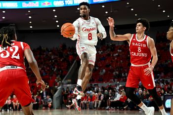 Nov 13, 2024; Houston, Texas, USA; Houston Cougars guard Mylik Wilson (8) looks to pass the ball as Louisiana Ragin Cajuns guard Mostapha El Moutaouakkil (8) defends during the second half at Fertitta Center. The Cougars defeated the Ragin Cajuns 91-45. Mandatory Credit: Maria Lysaker-Imagn Images