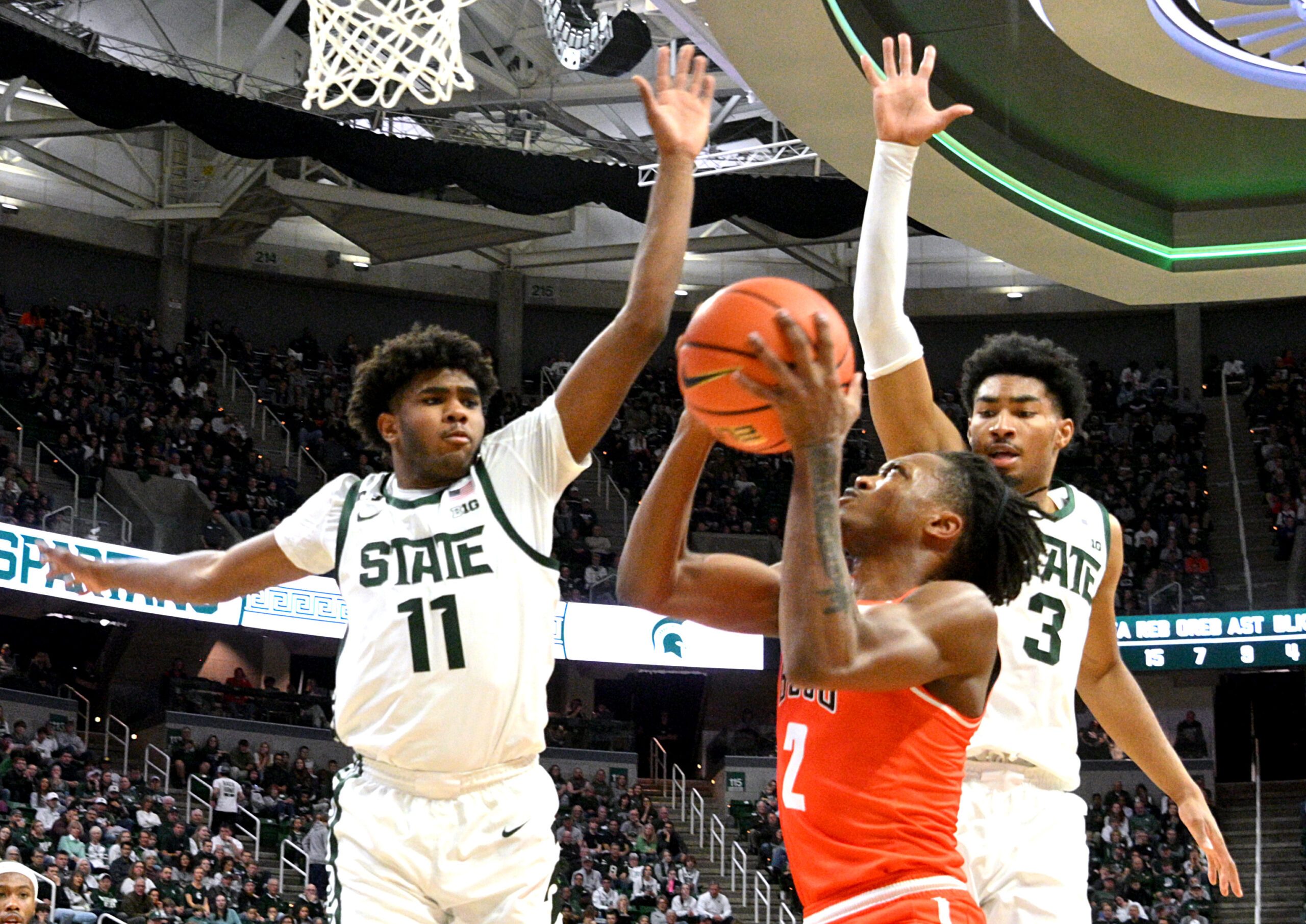 Nov 16, 2024; East Lansing, Michigan, USA;  Bowling Green Falcons guard Javontae Campbell (2) gets stopped by Michigan State Spartans guards Jase Richardson (11) and Jaden Akins (3) during the first half at Jack Breslin Student Events Center. Mandatory Credit: Dale Young-Imagn Images