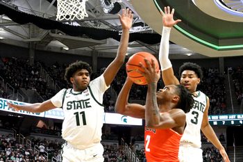 Nov 16, 2024; East Lansing, Michigan, USA;  Bowling Green Falcons guard Javontae Campbell (2) gets stopped by Michigan State Spartans guards Jase Richardson (11) and Jaden Akins (3) during the first half at Jack Breslin Student Events Center. Mandatory Credit: Dale Young-Imagn Images