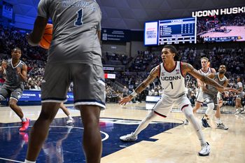 Nov 19, 2024; Storrs, Connecticut, USA; Connecticut Huskies guard Solo Ball (1) defends the inbound pass by Texas A&M Commerce guard Scooter Williams Jr. (1) during the second half at Harry A. Gampel Pavilion. Mandatory Credit: Mark Smith-Imagn Images