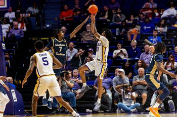 Nov 19, 2024; Baton Rouge, Louisiana, USA;  LSU Tigers forward Daimion Collins (10) shoots a jump shot against Charleston Southern Buccaneers guard Daylen Berry (7) during the second half at Pete Maravich Assembly Center. Mandatory Credit: Stephen Lew-Imagn Images
