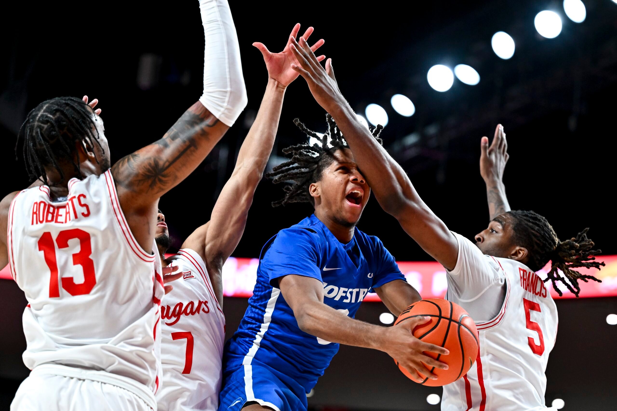 Nov 22, 2024; Houston, Texas, USA; Houston Cougars forward Ja'Vier Francis (5) fouls Hofstra Pride guard KiJan Robinson (0) during the first half at Fertitta Center. Mandatory Credit: Maria Lysaker-Imagn Images