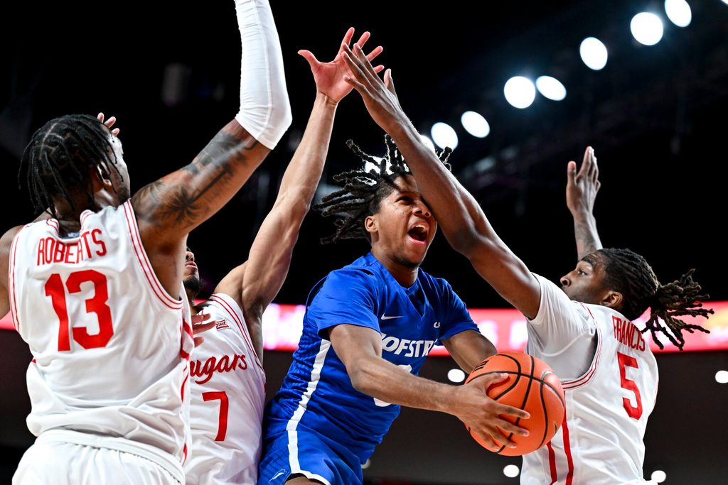Nov 22, 2024; Houston, Texas, USA; Houston Cougars forward Ja'Vier Francis (5) fouls Hofstra Pride guard KiJan Robinson (0) during the first half at Fertitta Center. Mandatory Credit: Maria Lysaker-Imagn Images