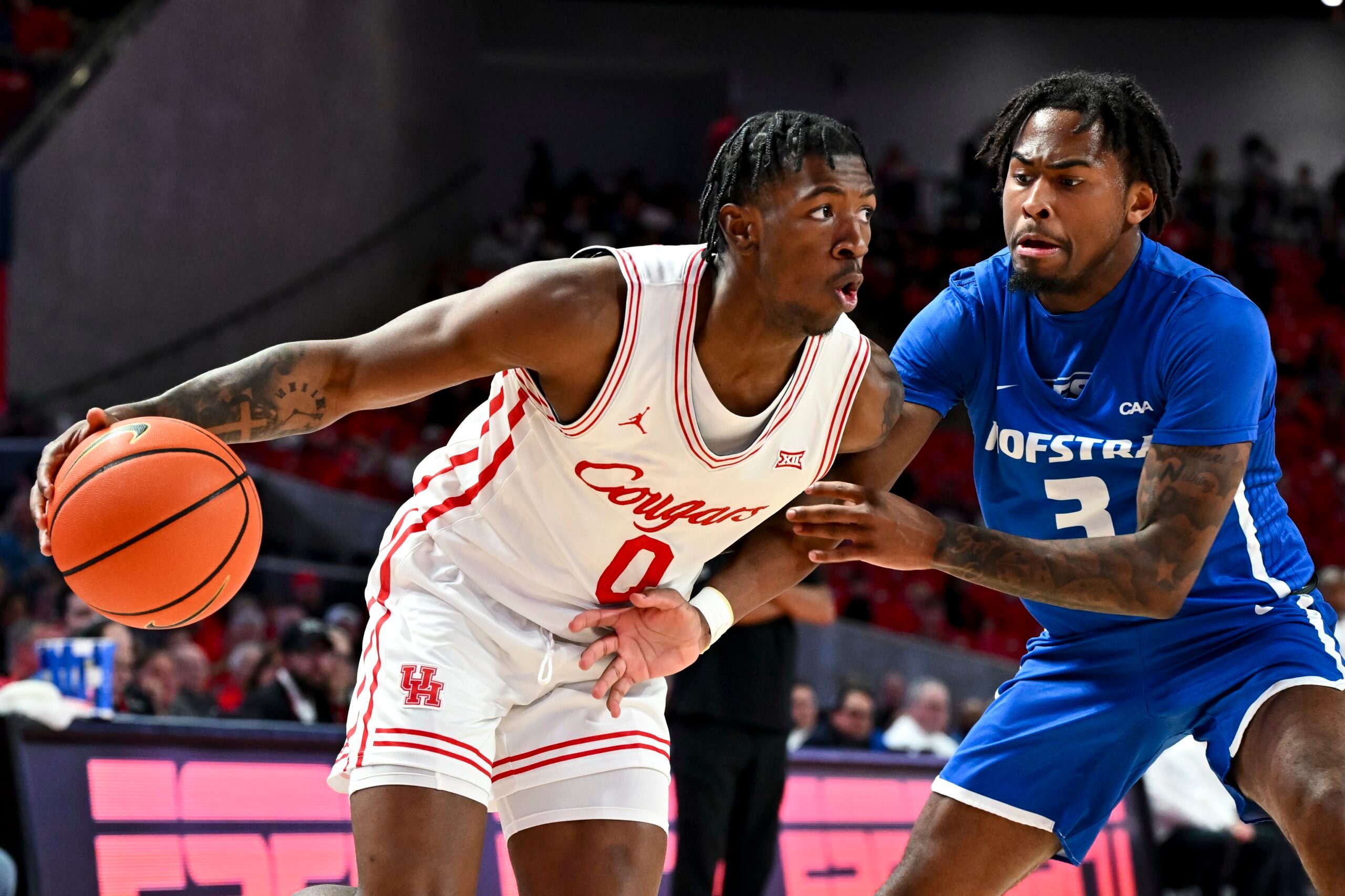 Nov 22, 2024; Houston, Texas, USA; Houston Cougars guard Kordelius Jefferson (0) drives against Hofstra Pride guard Khalil Farmer (3) during the second half at Fertitta Center. Mandatory Credit: Maria Lysaker-Imagn Images