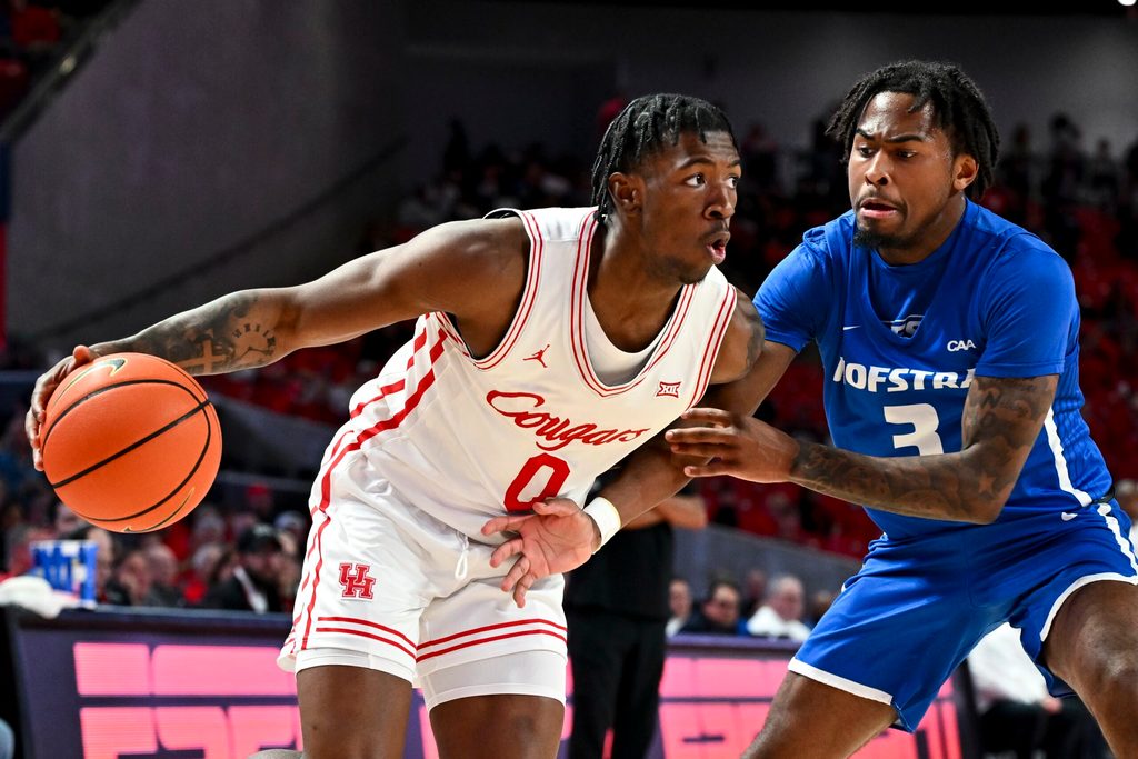 Nov 22, 2024; Houston, Texas, USA; Houston Cougars guard Kordelius Jefferson (0) drives against Hofstra Pride guard Khalil Farmer (3) during the second half at Fertitta Center. Mandatory Credit: Maria Lysaker-Imagn Images