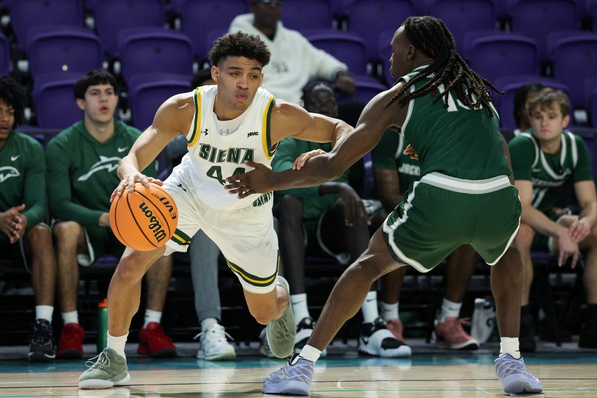 Nov 26, 2024; Fort Myers, Florida, USA; Siena Saints guard Marcus Jackson (44) is guided by Jacksonville Dolphins guard Robert McCray V (13) in the first half at Suncoast Credit Union Arena. Mandatory Credit: Nathan Ray Seebeck-Imagn Images