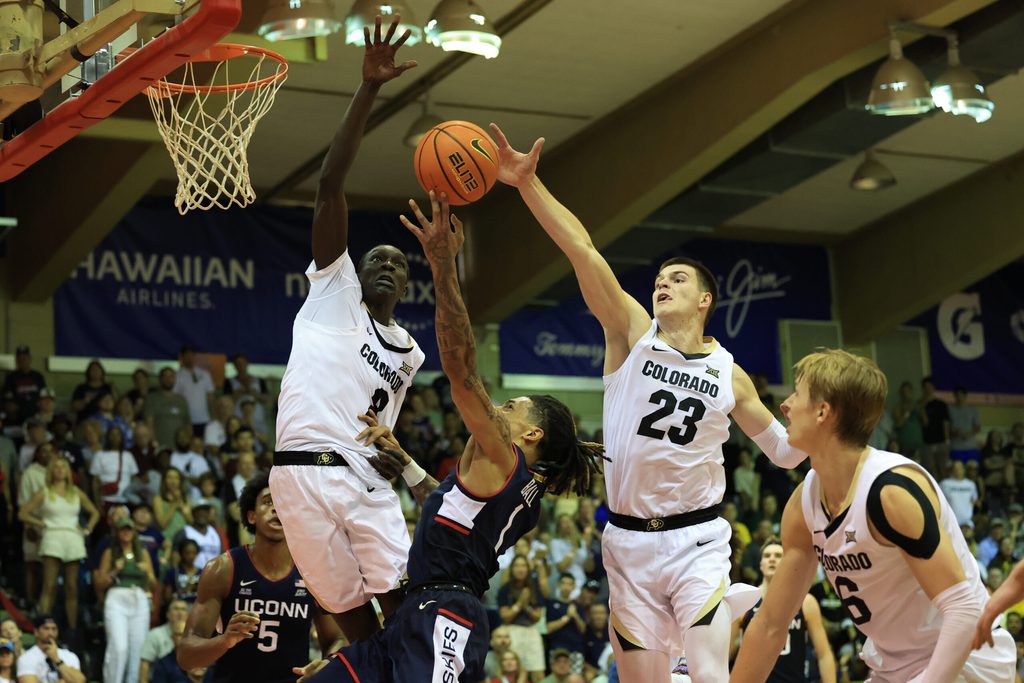 Nov 26, 2024; Lahaina, Hawaii, USA;  Connecticut Huskies guard Solo Ball (1) makes a layup in between Colorado Buffaloes forward Bangot Dak (8) and forward Andrej Jakimovski (23) during the second half of an NCAA college basketball game at Lahaina Civic Center. Mandatory Credit: Marco Garcia-Imagn Images