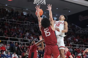 Nov 30, 2024; Queens, New York, USA;  St. John's Red Storm guard RJ Luis Jr. (12) drives past Harvard Crimson forward Thomas Batties II (15) in the second half at Carnesecca Arena. Mandatory Credit: Wendell Cruz-Imagn Images