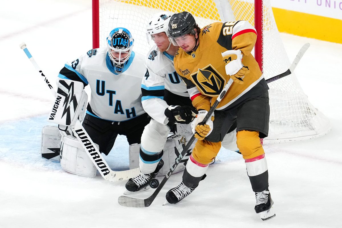 Nov 30, 2024; Las Vegas, Nevada, USA; Utah Hockey Club defenseman Juuso Valimaki (4) fends off Vegas Golden Knights right wing Alexander Holtz (26) as Utah Hockey Club goaltender Jaxson Stauber (33) defends his net during the third period at T-Mobile Arena. Mandatory Credit: Stephen R. Sylvanie-Imagn Images