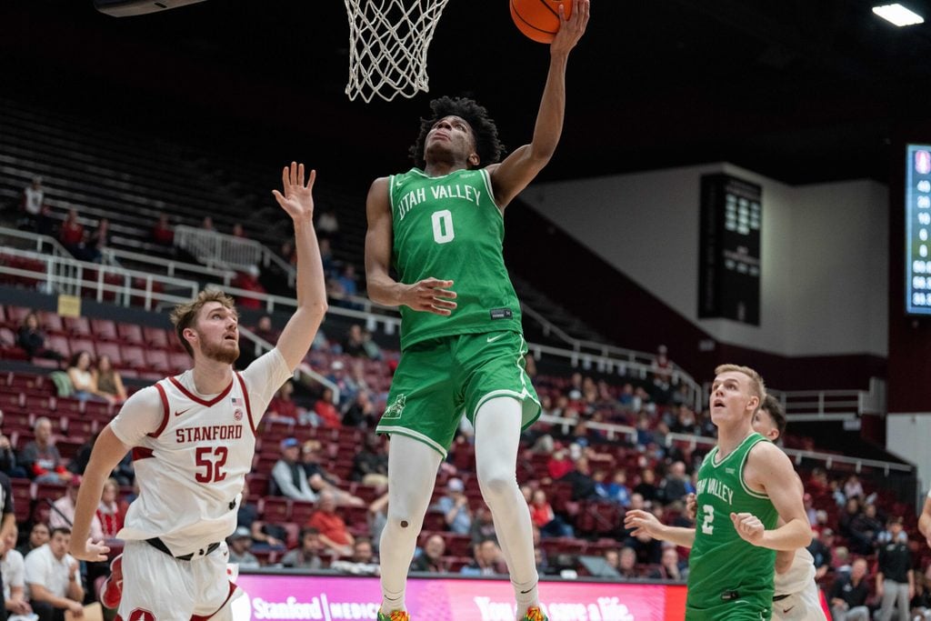 Dec 3, 2024; Stanford, California, USA; Utah Valley Wolverines guard Dominick Nelson (0) shoots a layup against Stanford Cardinal forward Aidan Cammann (52) during the second half at Maples Pavilion. Mandatory Credit: Neville E. Guard-Imagn Images