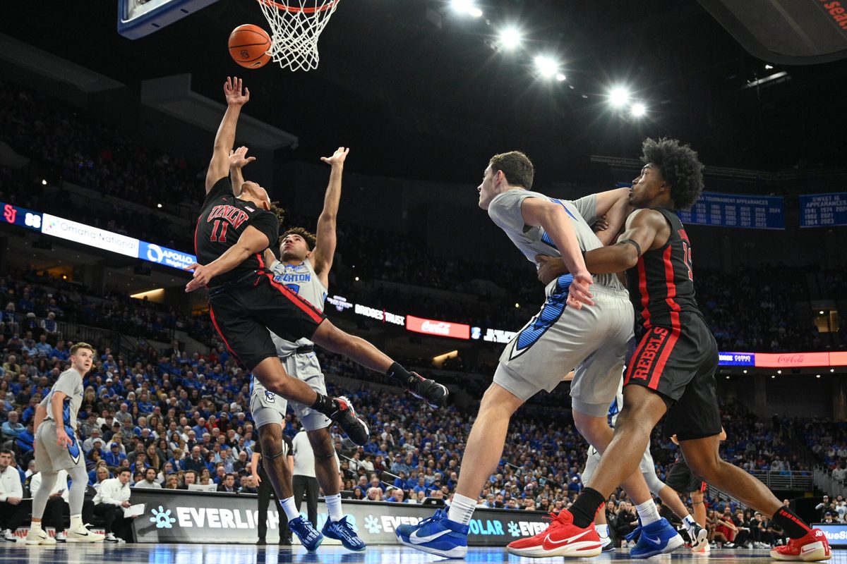 Dec 7, 2024; Omaha, Nebraska, USA;  UNLV Rebels guard Dedan Thomas Jr. (11) attempts a shot against Creighton Bluejays forward Jasen Green (0) and center Ryan Kalkbrenner (11) in the first half at CHI Health Center Omaha. Mandatory Credit: Steven Branscombe-Imagn Images