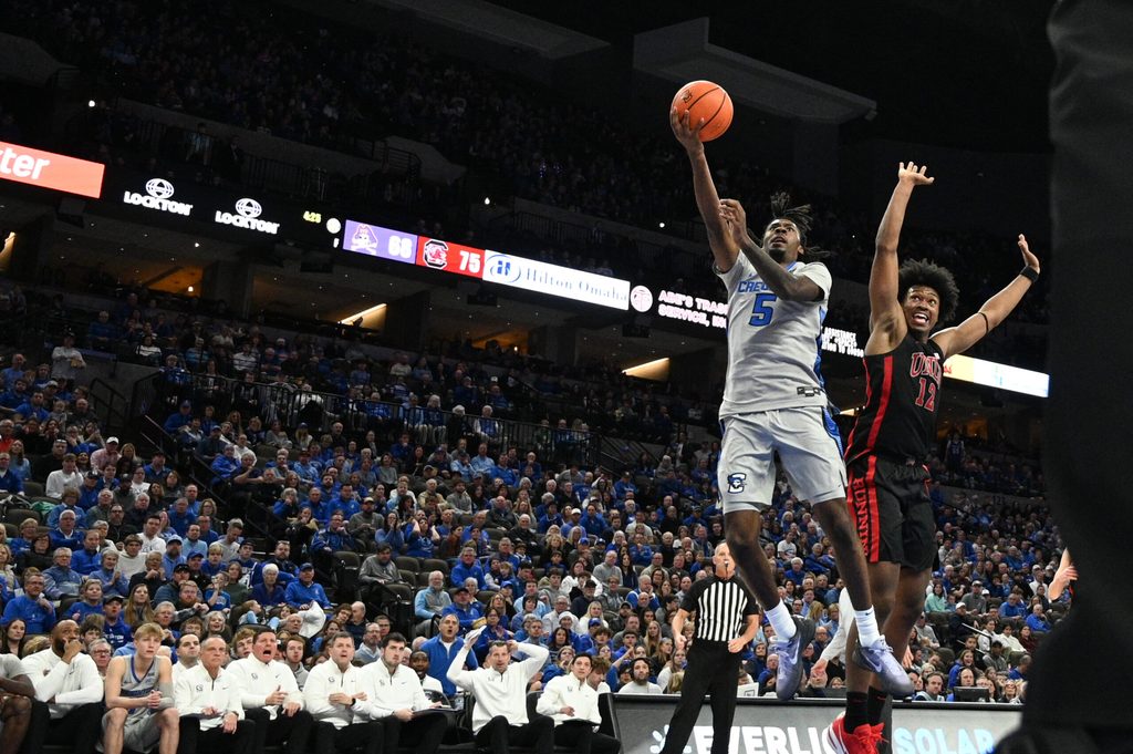 Dec 7, 2024; Omaha, Nebraska, USA; Creighton Bluejays guard Jamiya Neal (5) scores against UNLV Rebels forward Jacob Bannarbie (12) in the second half at CHI Health Center Omaha. Mandatory Credit: Steven Branscombe-Imagn Images