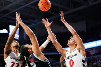 Cincinnati Bearcats forward Arrinten Page (22), Cincinnati Bearcats guard Dan Skillings Jr. (0) and Howard Bison forward Dom Campbell (2) battle to gain possession of a loose ball in the first half of a college basketball game between the Cincinnati Bearcats and Howard Bison, Sunday, Dec. 8, 2024, at Fifth Third Arena in Cincinnati.