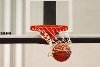 A basketball swishes the net as it goes through the hoop.