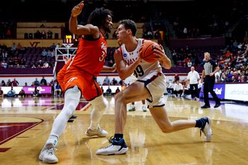 Dec 15, 2024; Blacksburg, Virginia, USA; Navy Midshipmen center Aidan Kehoe (99) drives to the basket against Virginia Tech Hokies forward Mylyjael Poteat (34) during the second half at Cassell Coliseum. Mandatory Credit: Peter Casey-Imagn Images