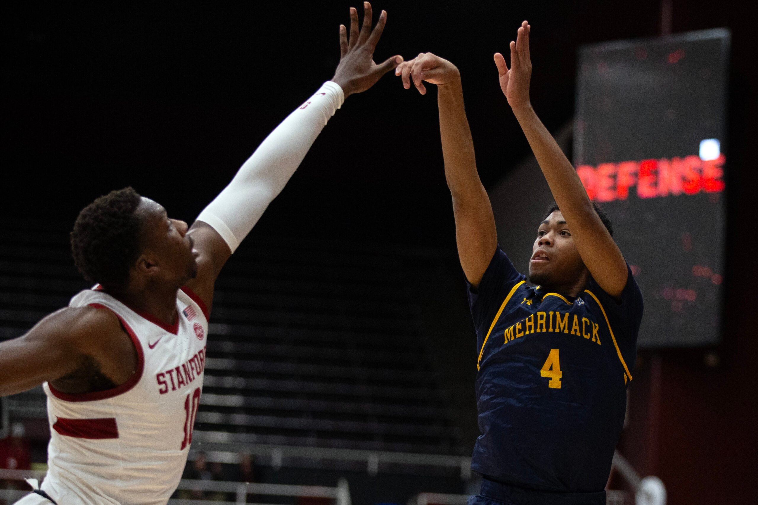Dec 17, 2024; Stanford, California, USA; Merrimack Warriors guard Tye Dorset (4) shoots a three-point basket over Stanford Cardinal forward Chisom Okpara (10) during the first half at Maples Pavilion. Mandatory Credit: D. Ross Cameron-Imagn Images