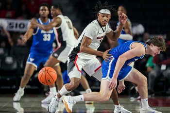 Dec 19, 2024; Athens, Georgia, USA; Georgia Bulldogs guard Tyrin Lawrence (7) steals the ball from Buffalo Bulls guard Ryan Sabol (2) at Stegeman Coliseum. Mandatory Credit: Dale Zanine-Imagn Images