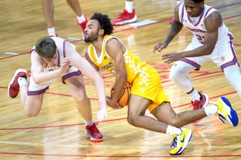 Bradley’s Almar Atlason, left, and Canisius’ Paul McMillan IV collide while chasing a loose ball in the first half of their college basketball game Saturday, Dec. 21, 2024 at Carver Arena. The Braves routed the Golden Griffins 92-59.