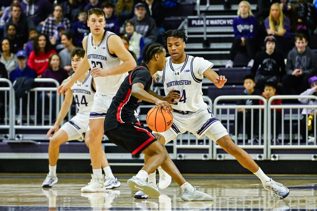 Dec 29, 2024; Evanston, Illinois, USA; Northeastern Huskies guard LA Pratt (3) moves the ball against Northwestern Wildcats guard K.J. Windham (24) during the second half at Welsh-Ryan Arena. Mandatory Credit: Matt Marton-Imagn Images