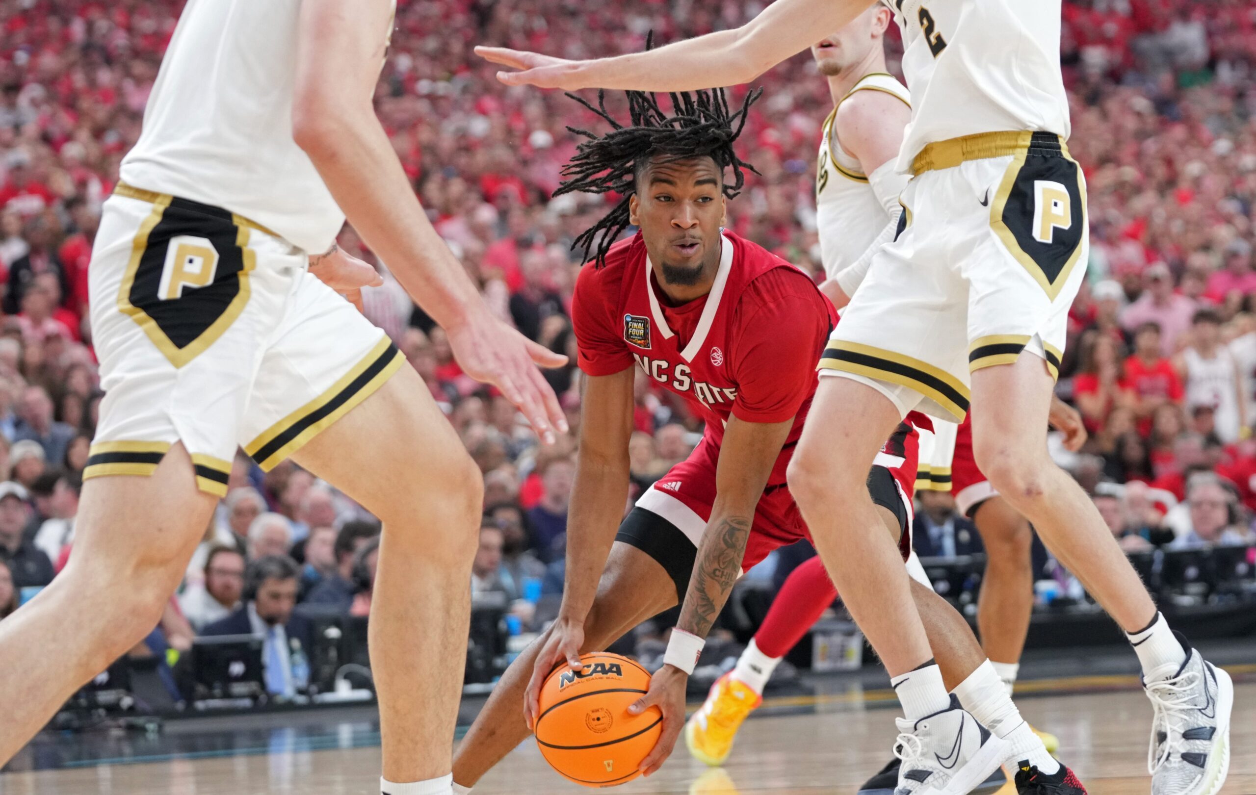 North Carolina State Wolfpack guard Jayden Taylor (1) drives into Purdue Boilermakers guard Fletcher Loyer (2) during the NCAA Men's Basketball Tournament Final Four game, Saturday, April 6, 2024, at State Farm Stadium in Glendale, Ariz.