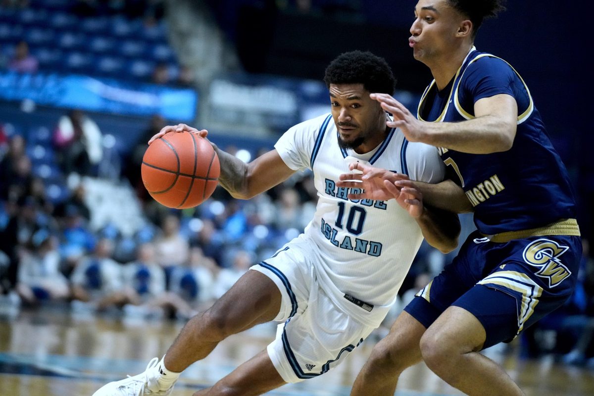 Jamarques Lawrence of URI drives into George Washington defender Dayan Nessah.