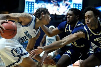 Rams forward Tyonne Farrell runs in to a wall of Revolutionaries, Gerald Drumgoole Jr. and form PC Friar, Rafael Castro ,on his way to the hoop in the first half.