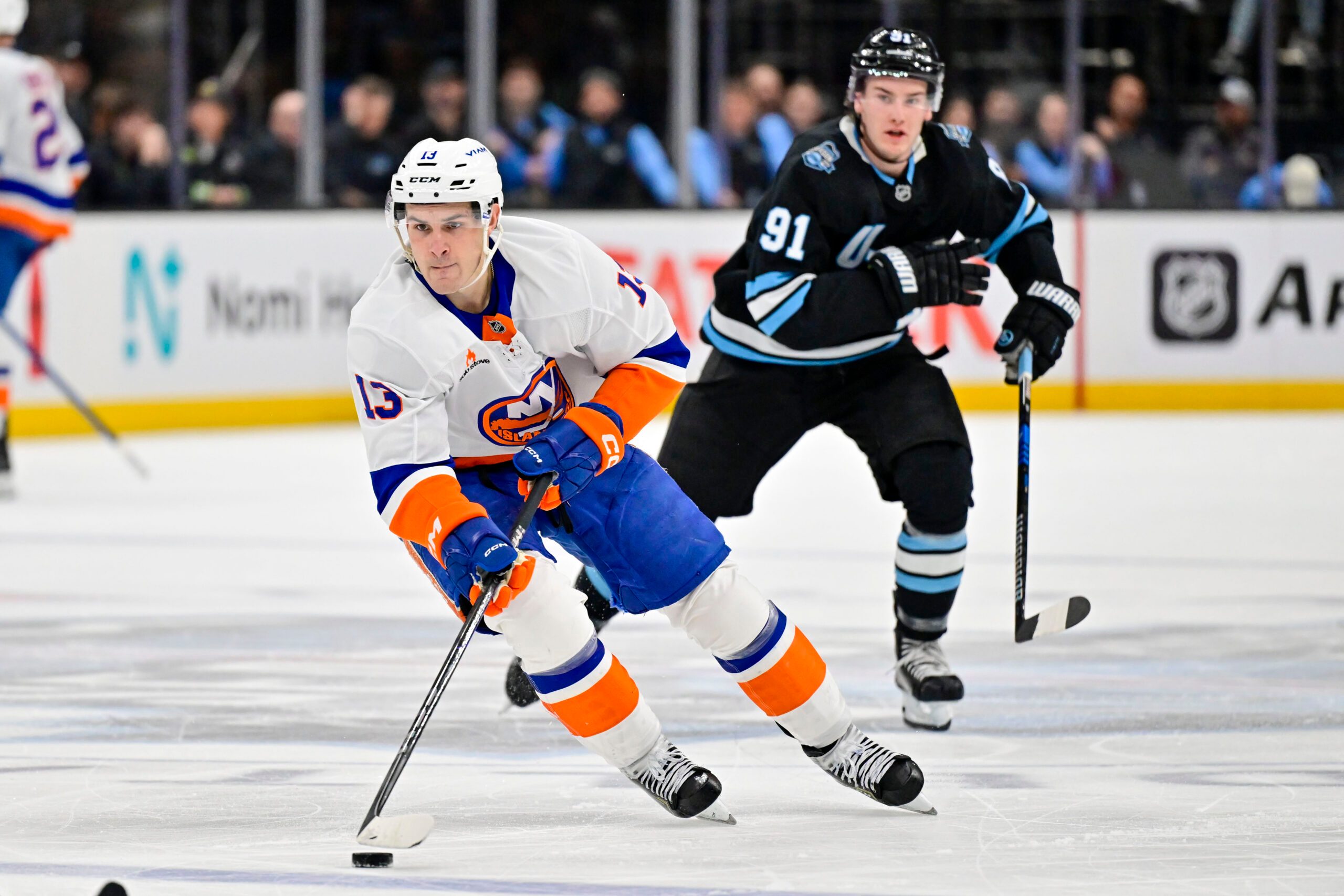 Jan 11, 2025; Salt Lake City, Utah, USA; New York Islanders center Mathew Barzal (13) makes a fast break against Utah Hockey Club right wing Josh Doan (91) during third period at the Delta Center. Mandatory Credit: Christopher Creveling-Imagn Images