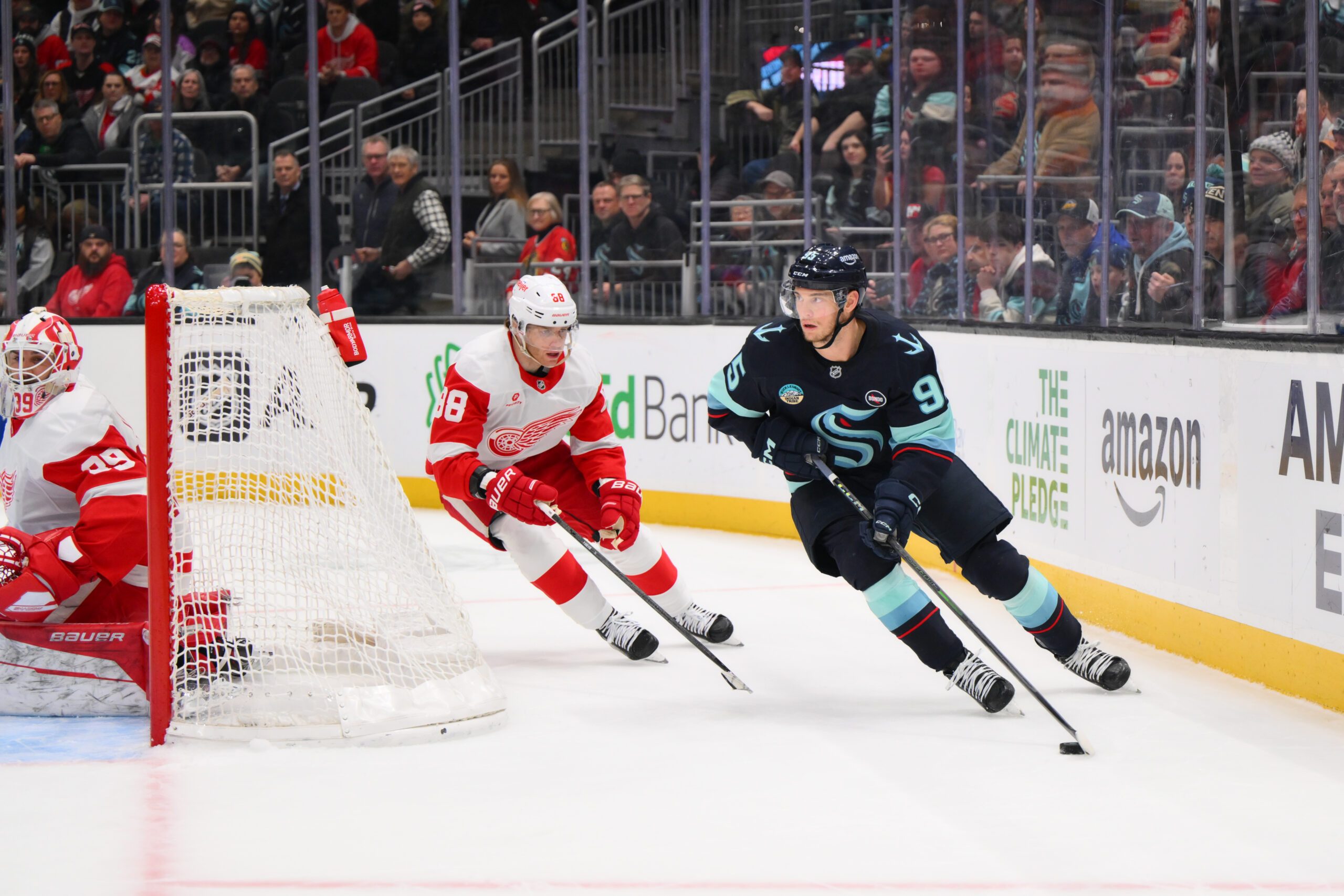 Feb 4, 2025; Seattle, Washington, USA; Seattle Kraken left wing Andre Burakovsky (95) plays the puck while defended by Detroit Red Wings right wing Patrick Kane (88) during overtime at Climate Pledge Arena. Mandatory Credit: Steven Bisig-Imagn Images