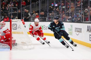 Feb 4, 2025; Seattle, Washington, USA; Seattle Kraken left wing Andre Burakovsky (95) plays the puck while defended by Detroit Red Wings right wing Patrick Kane (88) during overtime at Climate Pledge Arena. Mandatory Credit: Steven Bisig-Imagn Images