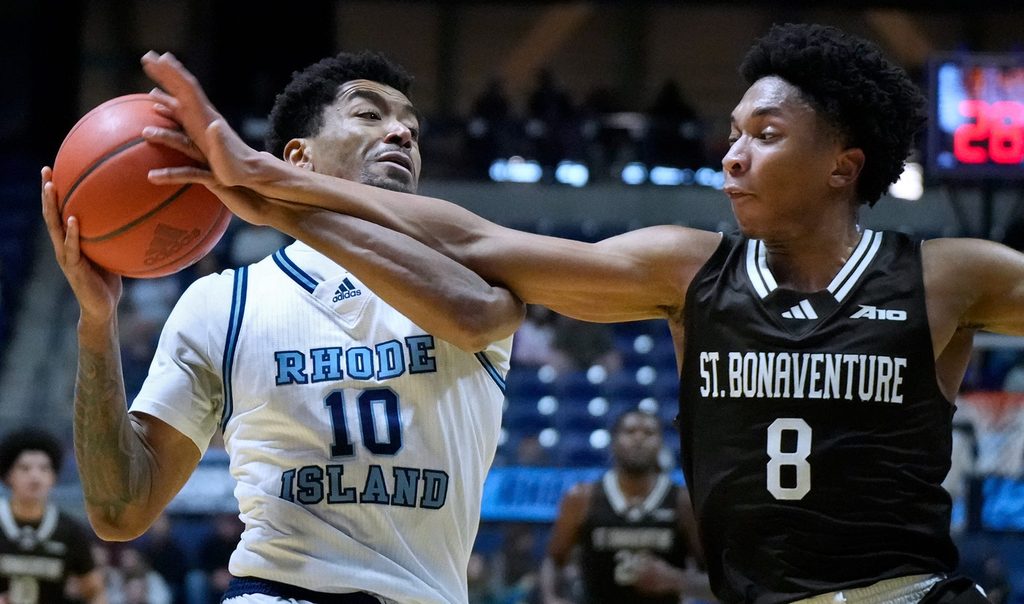URI Rams guard Jamarques Lawrence fiends off the reaching arm of St. Bonaventure's Jonah Hinton during first half action.