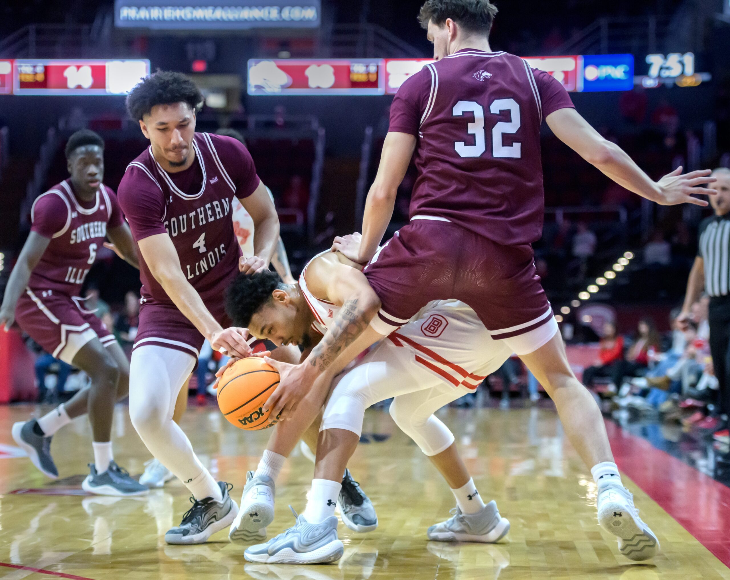 Southern Illinois’ Davion Sykes (4) and Jarrett Hensley (32) pressure Bradley’s Zek Montgomery in the first half of their MVC basketball game Wednesday, Feb. 12, 2025 at Carver Arena in Peoria. The Braves defeated the Salukis 78-64.