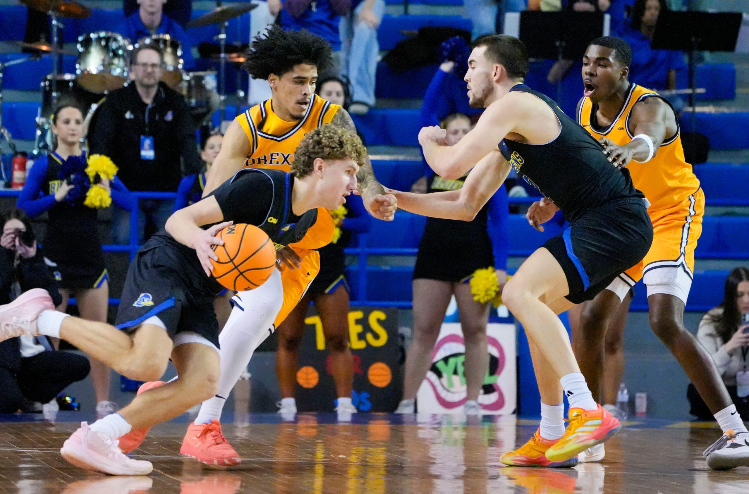 Delaware's Cavan Reilly (left) drives against Drexel's Kobe MaGee as Blue Hen John Camden works in front of Drexel's Shane Blakeney in the first half at the Bob Carpenter Center, Thursday, Feb. 20, 2025.