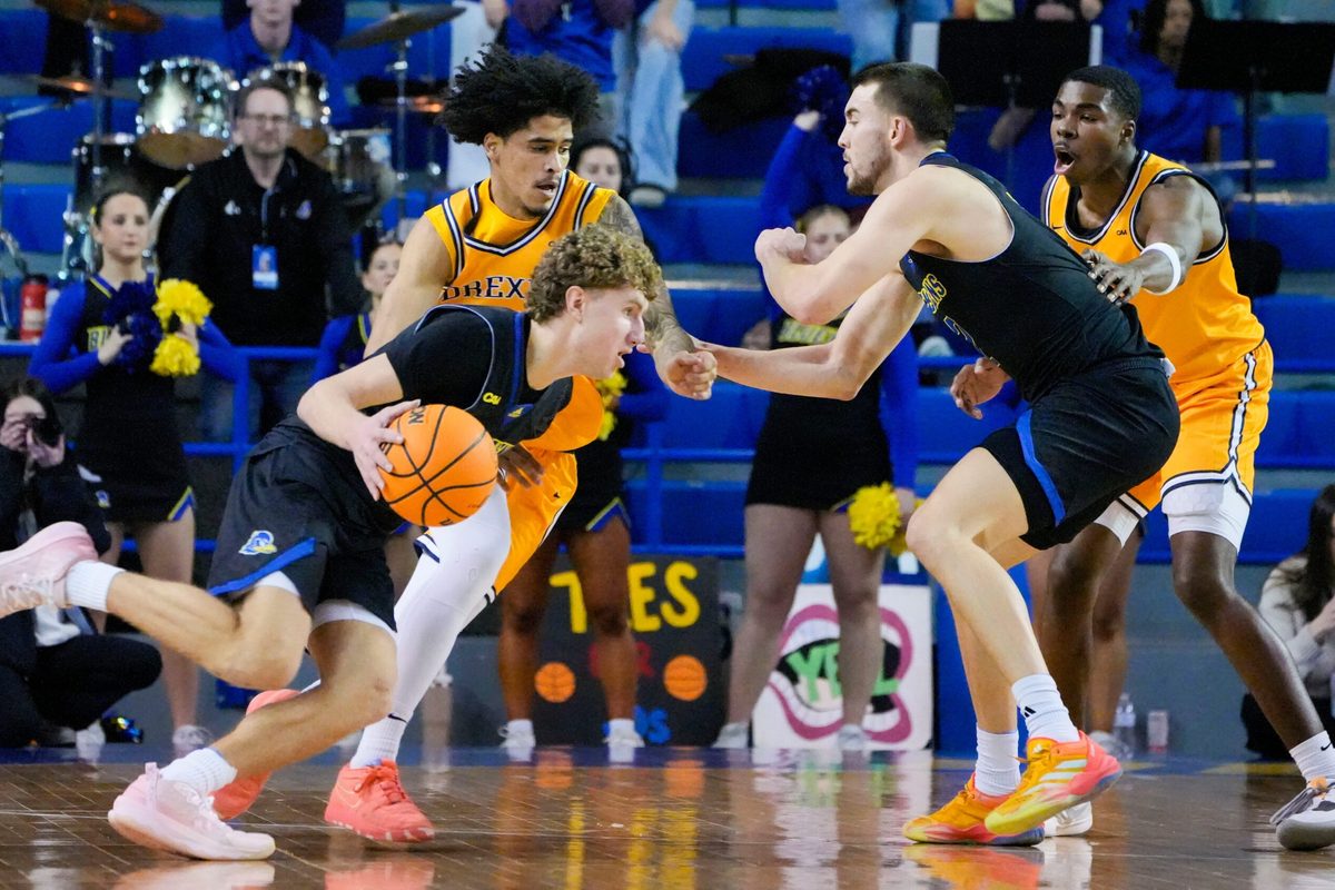 Delaware's Cavan Reilly (left) drives against Drexel's Kobe MaGee as Blue Hen John Camden works in front of Drexel's Shane Blakeney in the first half at the Bob Carpenter Center, Thursday, Feb. 20, 2025.