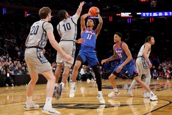 Mar 12, 2025; New York, NY, USA; DePaul Blue Demons guard CJ Gunn (11) takes a shot against Georgetown Hoyas guard Jayden Epps (10) and forward Drew Fielder (20) during the first half at Madison Square Garden. Mandatory Credit: Brad Penner-Imagn Images