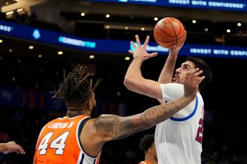 Mar 12, 2025; Charlotte, NC, USA; Southern Methodist Mustangs center Samet Yigitoglu (24) shoots as Syracuse Orange center Eddie Lampkin Jr. (44) defends in the first half at Spectrum Center. Mandatory Credit: Bob Donnan-Imagn Images